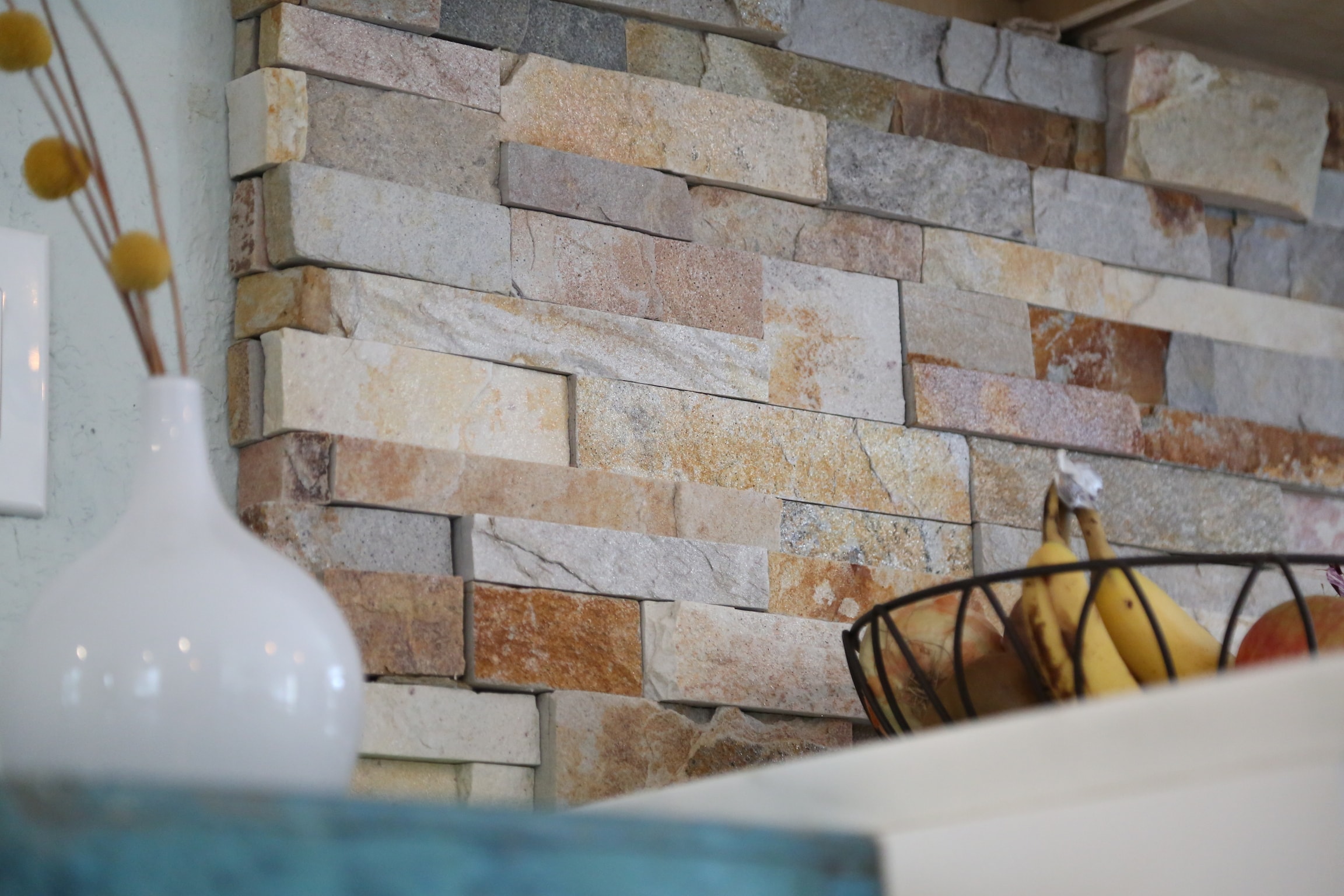 Light colored split face stone veneer used on a kitchen backsplash